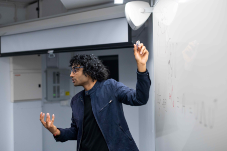 A photograph of someone stood in front of a whiteboard.