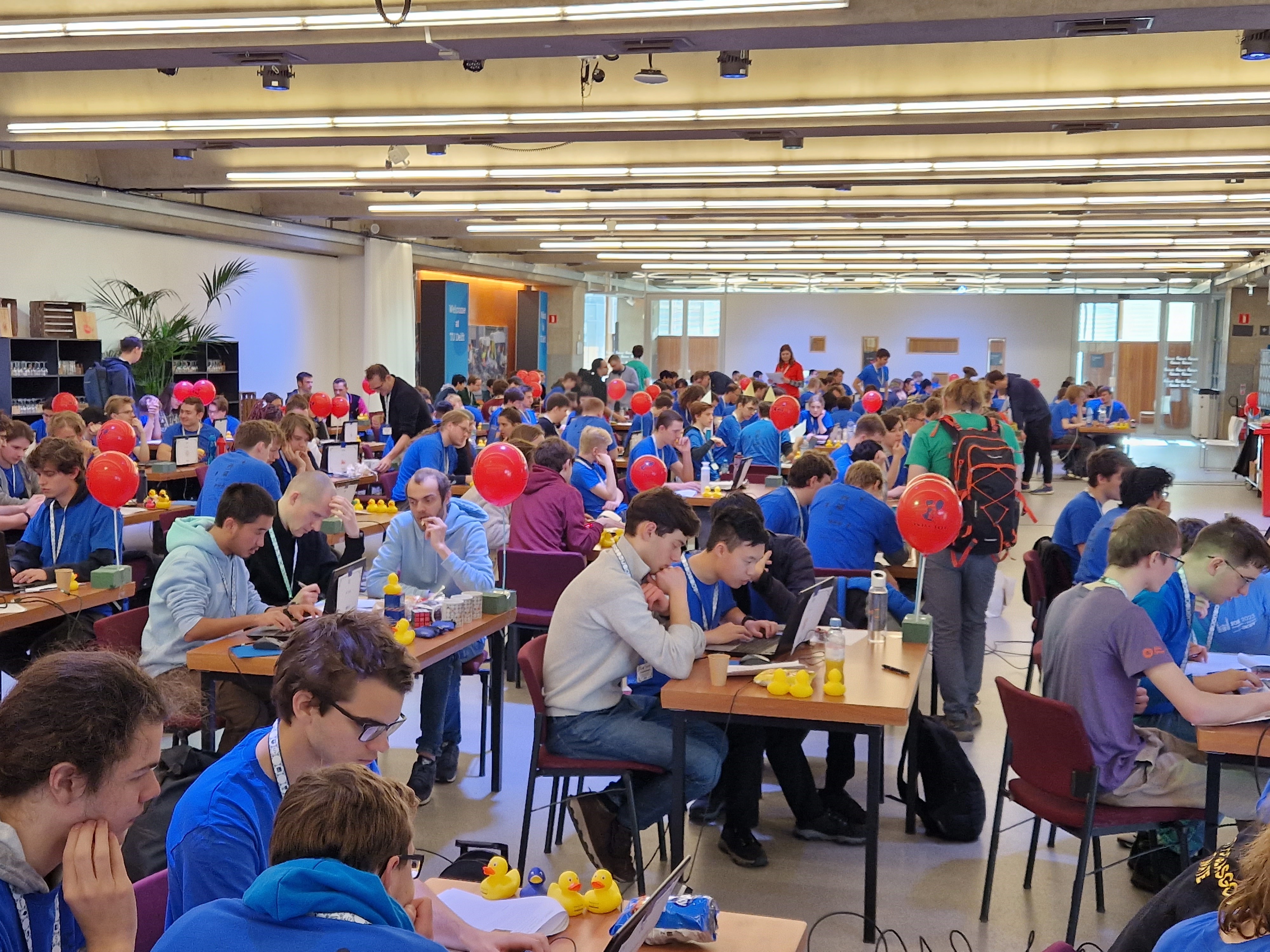 A room full of students sat in teams of three around tables solving computer programming problems.