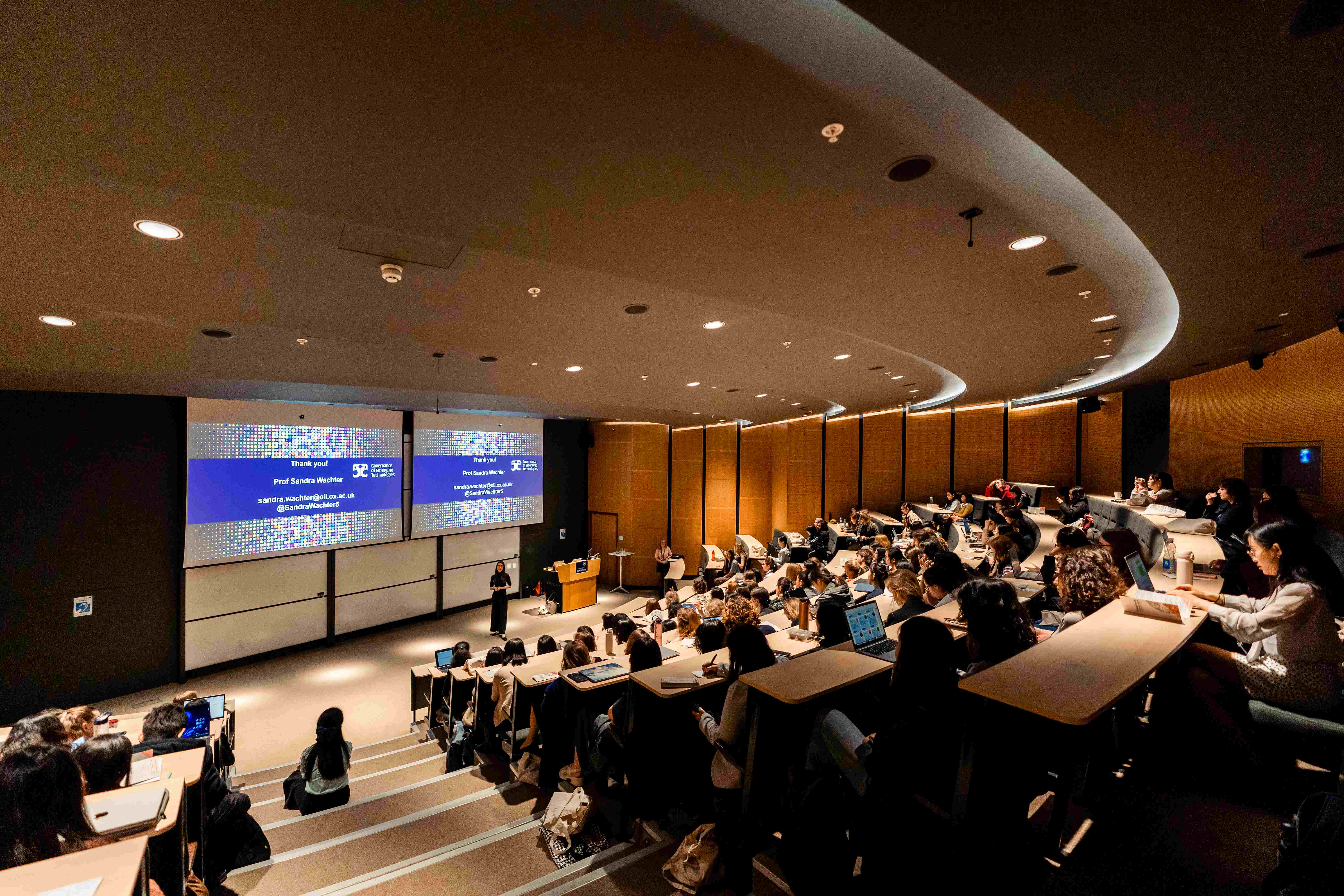 Photo shows a full lecture theatre at the Maths Institue as Professor Sandra Wachter of the Oxford Internet Institute gives a keynote speech